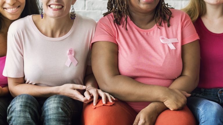 four wmen wearing pink and pink ribbons for breast cancer