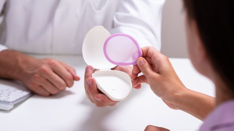 woman holding a pink diaphragm