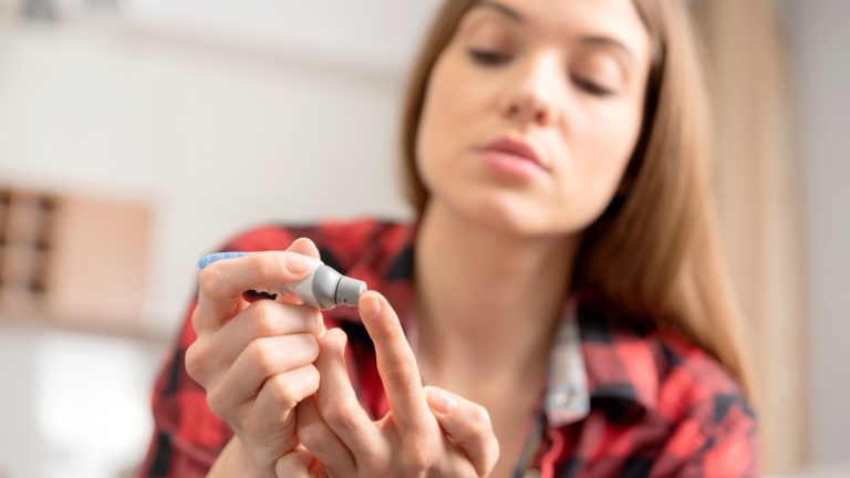 young woman checking her blood sugar