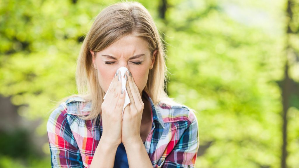 woman blowing her nose into a tissue