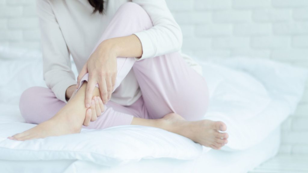 woman sitting on a bed with her legs crossed