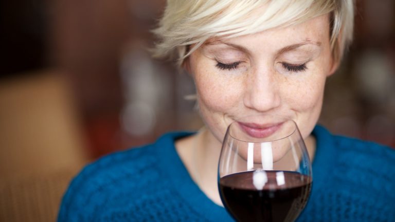 woman sniffing a glass of red wine