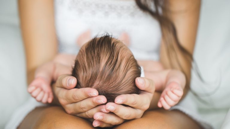 woman holding newborn baby on her lap