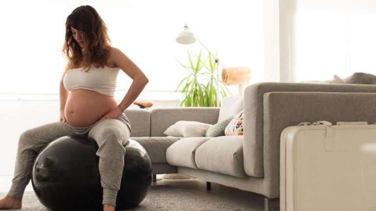 woman in labor sitting on exercise ball