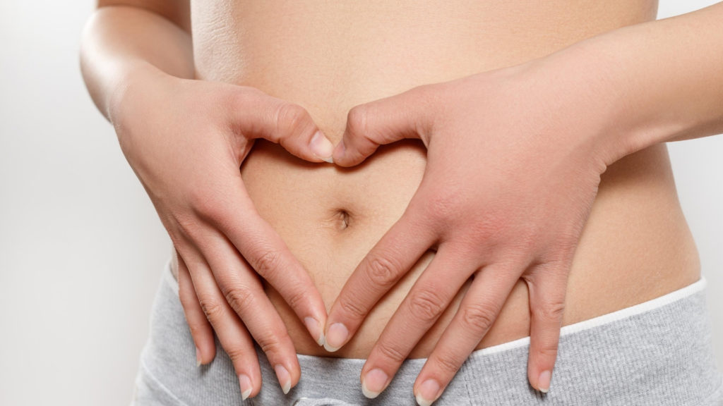 woman caressing her stomach in early pregnancy