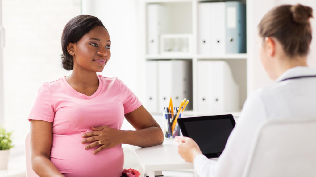 african american pregnant woman at a doctors appointment