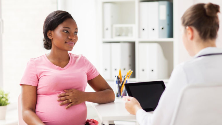 african american pregnant woman at a doctors appointment