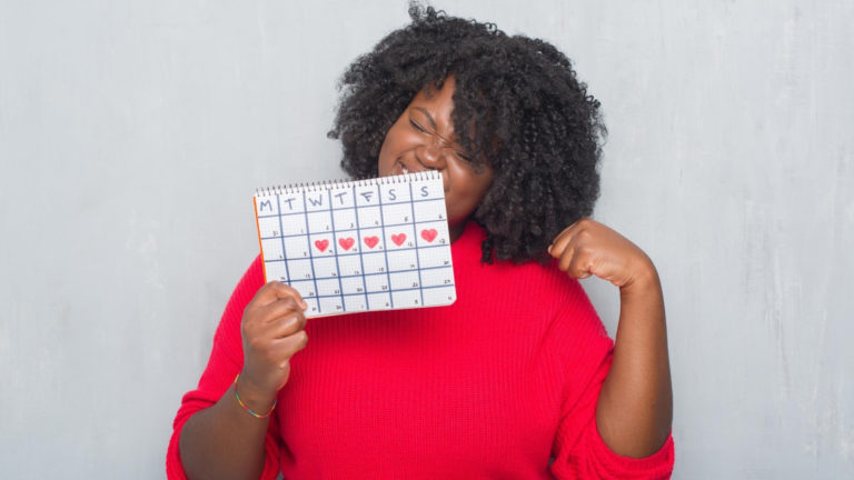 woman holding a period calendar tracker