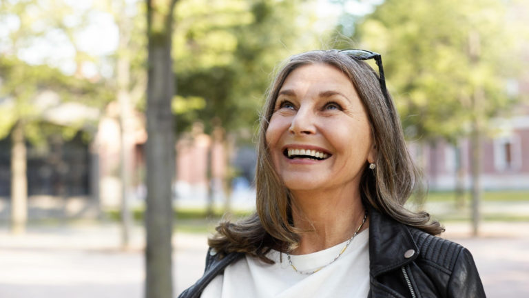 woman with grey hair wearing sunglasses and a leather jacket