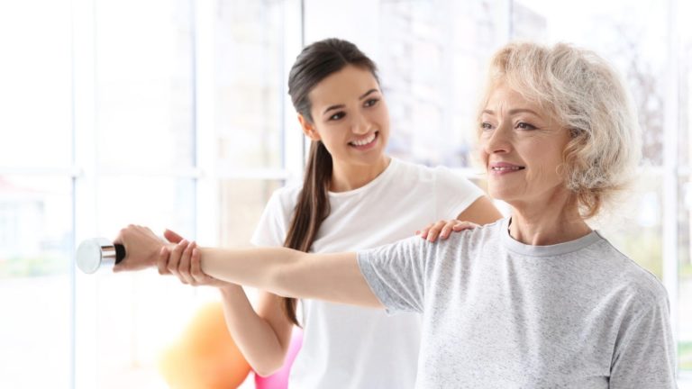 older woman working with a physical therapist