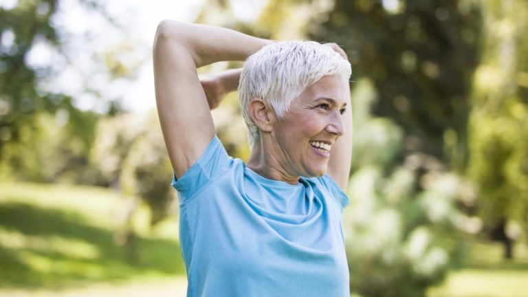 older woman outside stretching
