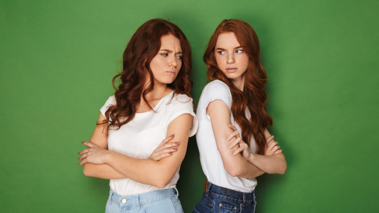 two angry girls faced away from each other