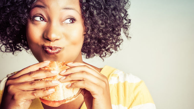 african american woman eating a hamburger