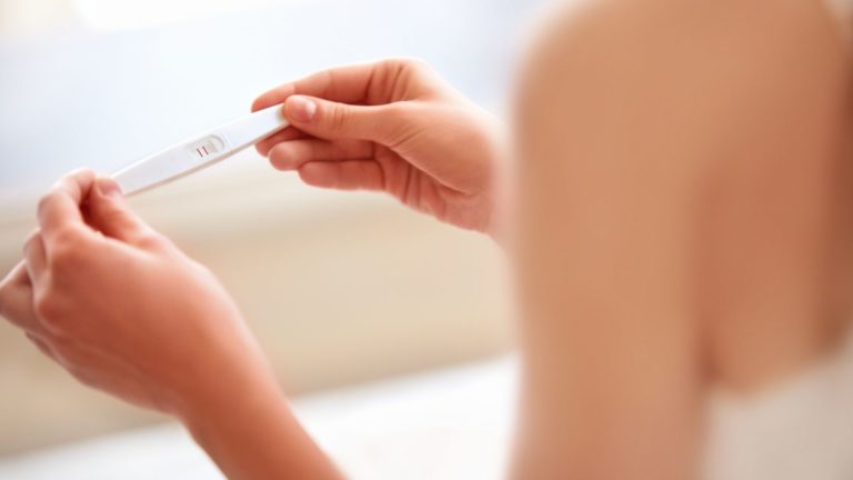 woman holding a positive pregnancy test