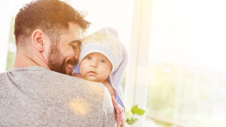 dad holding baby wrapped in towel
