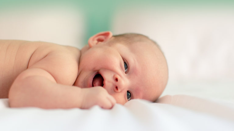 baby smiling on blanket