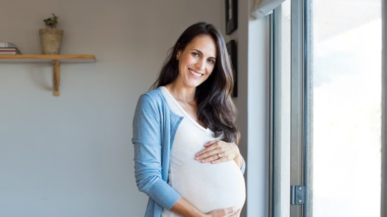 pregnant woman standing near window