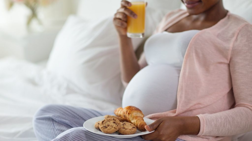 pregnant woman holding a plate of cookies